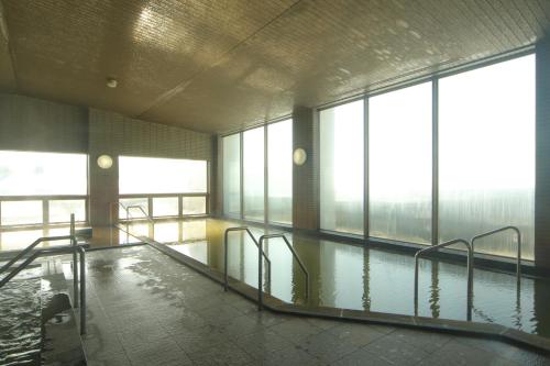 丰浦町Spa SHIOSAI的一座有窗户的建筑中的空游泳池