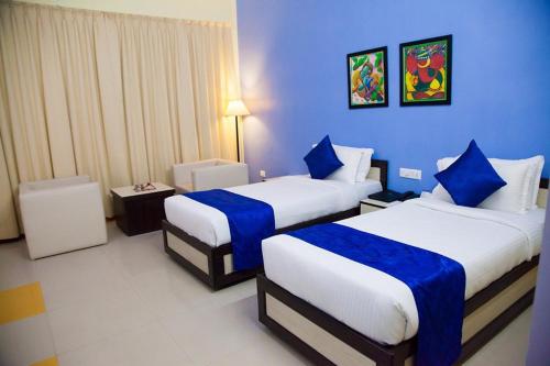 贾姆谢德布尔The Kannelite (Hotel Sakchi Vihar By JTDC)的酒店客房,设有两张带蓝色墙壁的床