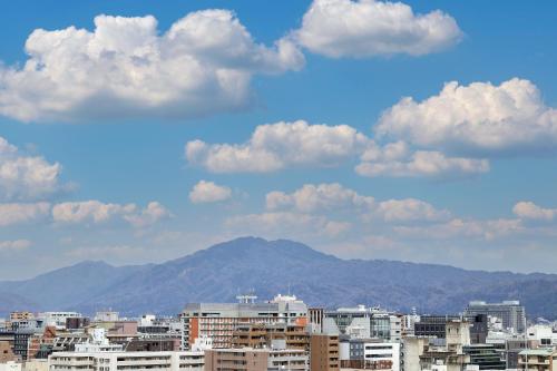 京都MYSTAYS 京都四条酒店的一座有建筑和山脉背景的城市