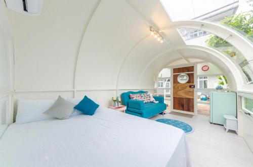 罗东镇曼漫森林的卧室配有白色的床和蓝色的沙发