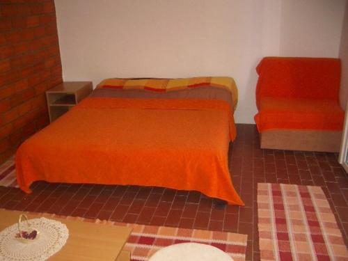格鲁达Apartment Dario的一间卧室配有一张带橙色毯子的床