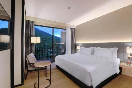普卡Grand ASTON Puncak Hotel & Resort的卧室设有白色的床和大窗户