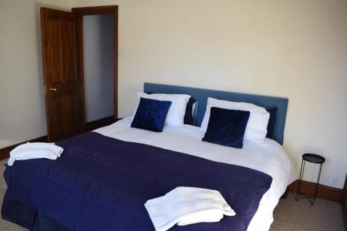 KentLovely 2 bedroom duplex apartment, Maidstone sleeps 5的一张配有蓝色和白色床单及枕头的大床