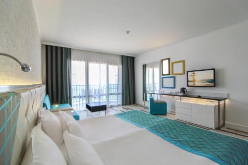 金沙Sentido Marea Hotel - 24 hours Ultra All inclusive & Private Beach的酒店客房设有白色的床和大窗户。