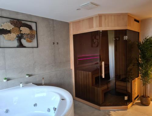 瓦拉日丁Wellness Apartments的设有带浴缸和淋浴的浴室。