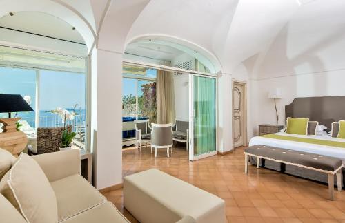 波西塔诺Hotel L'Ancora的一间卧室设有一张床和一间客厅。