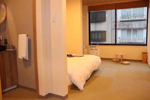 丰冈市城崎温泉 小宿 紬 tsumugi的客房设有床和带窗户的窗户。