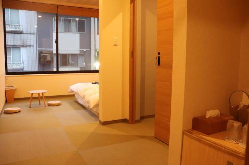 丰冈市城崎温泉 小宿 紬 tsumugi的小房间设有床和窗户