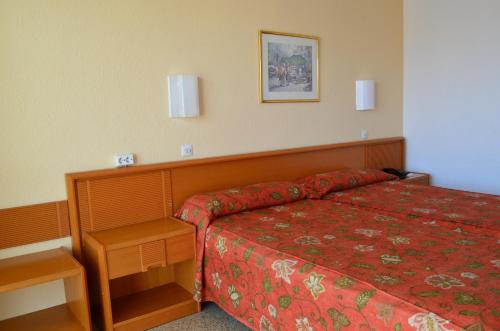 坎帕斯蒂利亚Linda的酒店客房,配有一张红色床罩的床