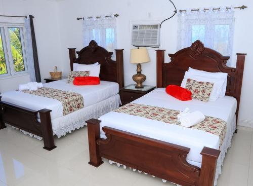Matthew TownRedknot Manor Guest house/Hotel的一间卧室配有两张带红色枕头的床