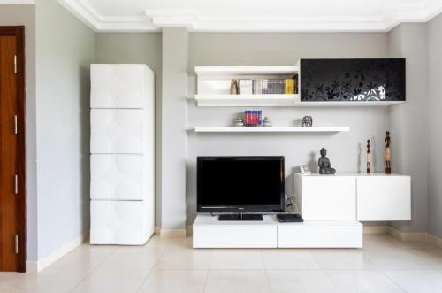 绍萨尔La Casita Gris的一间带电视和白色橱柜的客厅