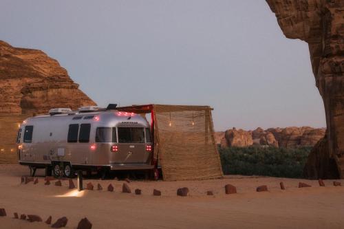 欧拉Caravan by Habitas AlUla的停在沙漠帐篷旁边的银色野营车
