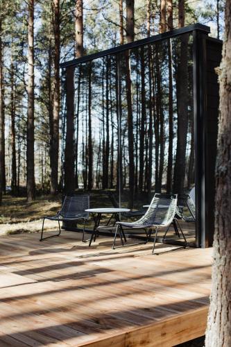 PunakiviÖÖD Hötels Laheranna SÄRA -with sauna的树上甲板上摆放着两把椅子和一张桌子