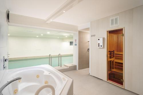 博尔库姆Hotel Haus am Park的一间位于客房内的带大型白色浴缸的浴室