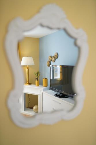 GüntherslebenQuartier Goldener Löwe的镜子反射着一个房间,里面配有电视和台灯