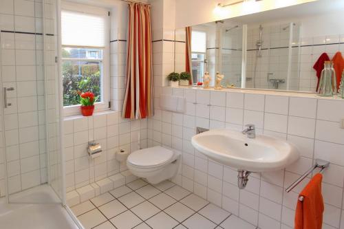 博尔滕哈根Feriendorf Papillon Wohnung 03-1的一间带水槽、卫生间和镜子的浴室