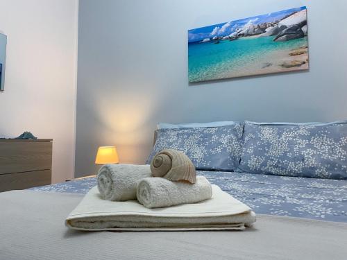 玛丽娜迪曼卡维萨Il profumo del mare的一间卧室配有一张床,床上有毛巾