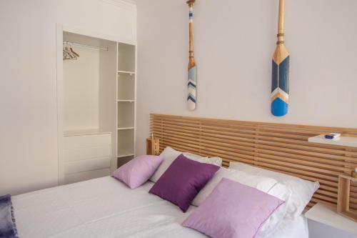 卡帕里卡海岸Sea, Surf & The City-RENOVATED APRIL 2022的一间卧室配有一张带紫色和白色枕头的床