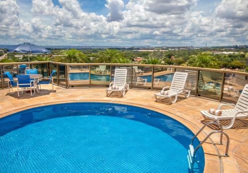 巴西利亚Brasil 21 Suites Affiliated by Meliá的一个带椅子和桌子的阳台的游泳池