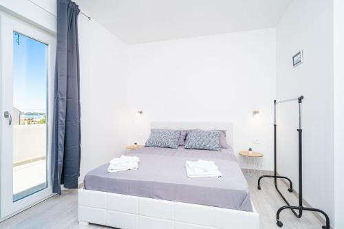 杜布罗夫尼克Apartment Olive的白色的卧室设有床和大窗户