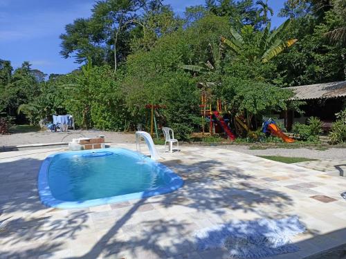 乌巴图巴Suites Brejauva的庭院里的小型游泳池,带游乐场