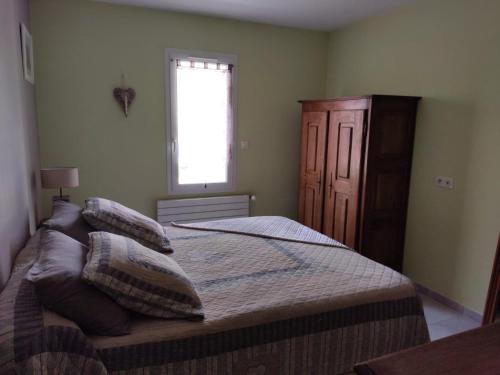 MusMAGNIFIQUE VILLA CONTEMPORAINE avec PISCINE的卧室配有带枕头的床铺和窗户。