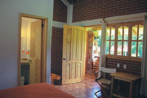 瓦斯卡坎波Cabañas Rincón Escondido的一间设有门和砖墙的房间