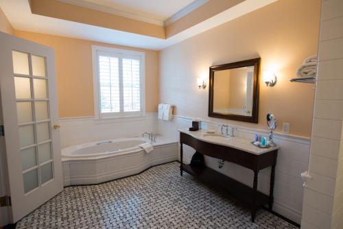 费尔伯恩Mills Park Hotel的带浴缸、水槽和镜子的浴室