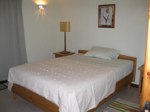 普拉兰大安塞区卡萨沃尔德酒店的一间卧室配有一张白色的床,上面有灯