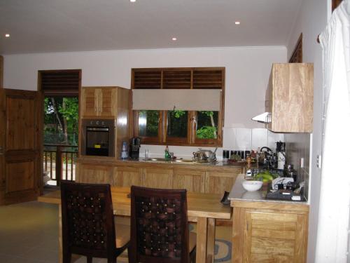 普拉兰大安塞区卡萨沃尔德酒店的厨房配有木制橱柜和桌椅