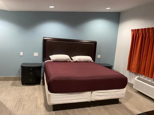 霍布斯Executive Inn的一张大床,位于一个红色墙壁的房间