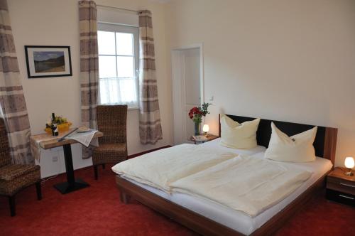 圣戈阿尔斯豪森纳绍尔霍夫酒店的一间卧室配有一张床、一张桌子和一个窗户。