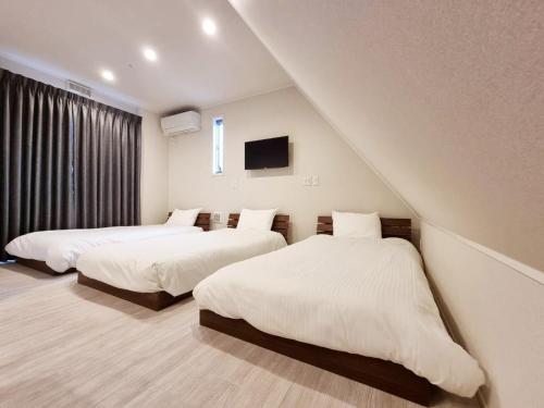 东京PRISM Inn Kamata的一间带两张床的卧室和一台电视
