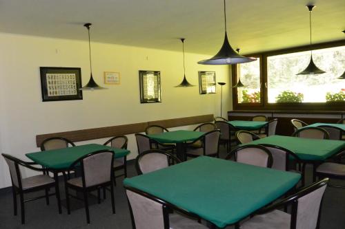 摩德纳迪-坎皮格里奥里奥法尔泽多功能酒店的用餐室配有绿色的桌椅