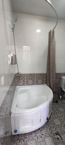 布哈拉Old Street Guesthouse的带淋浴的浴室内的白色浴缸