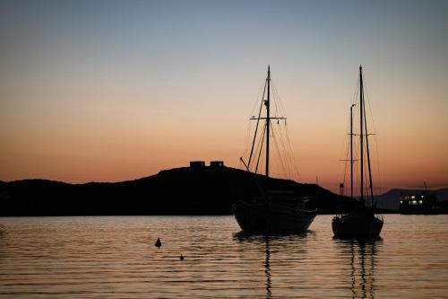 伊利达VILLA CARPE DIEM: sea & sunset view in Kea island的日落时分坐在水中的两艘船