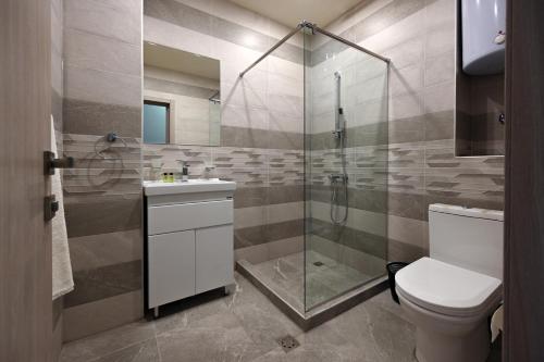 萨克德佐尔镇Forest Apartments Hotel的带淋浴、卫生间和盥洗盆的浴室