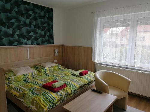 比克Kata vendégház的一间卧室配有一张带桌子和椅子的床