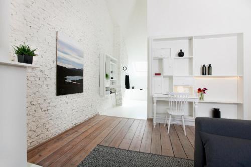 安特卫普国民城市公寓和套房酒店的白色的客厅,拥有白色的砖墙