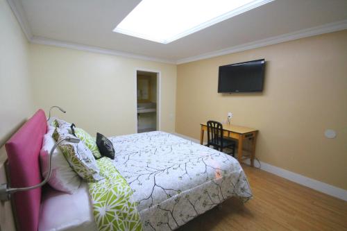 迈阿密辛巴达汽车旅馆的一间卧室配有一张床和一台平面电视