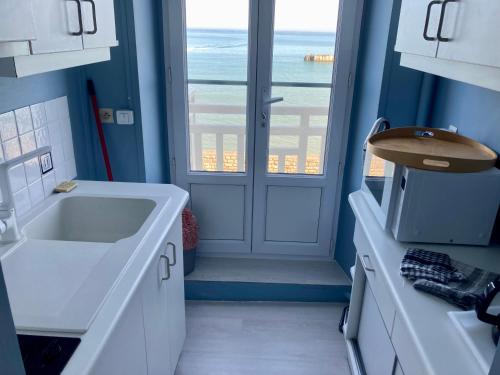 阿罗芒什莱班Appartement de standing - avec terrasse et vue mer的一间带水槽的浴室和一扇窗户的门
