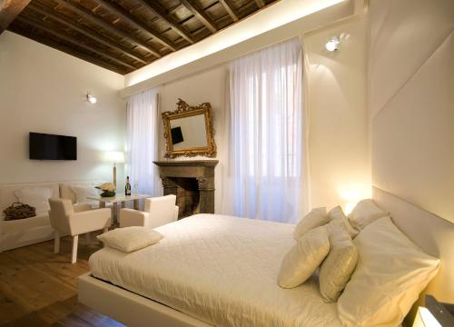 罗马吉格里多若套房酒店的一间白色卧室,配有一张床和一个壁炉