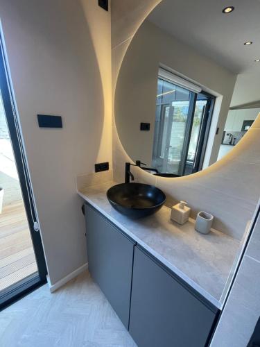 赞德沃特Amsterdam beach suite vlakbij zee的一间带水槽和圆形镜子的浴室