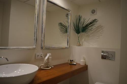 卡达克斯诺艾斯特乐斯酒店的浴室设有白色水槽和镜子