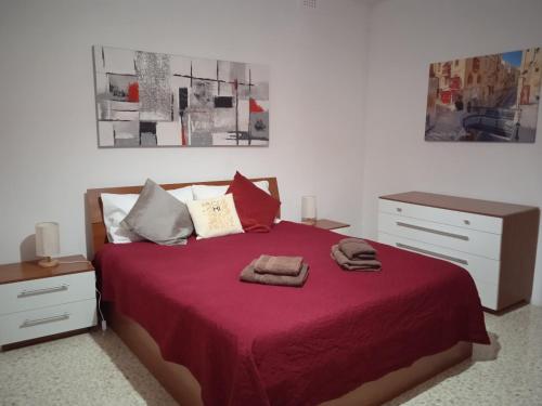 姆西达University Area Msida的一间卧室配有红色的床和2条毛巾
