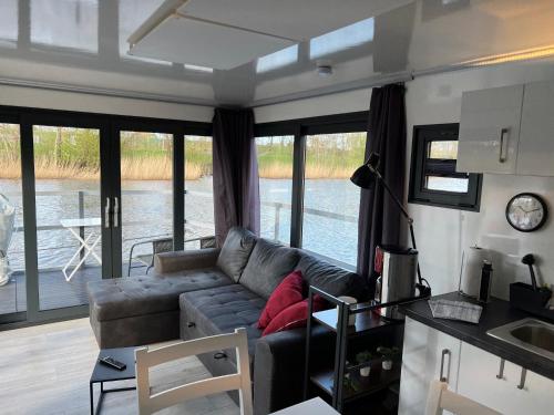 威廉港Hausboot Resort Nordseeküste的带沙发的客厅和带窗户的厨房