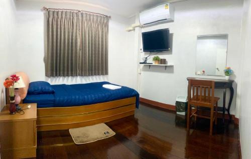 班敦孟The Best House&Hostel的小房间设有蓝色的床和一张书桌