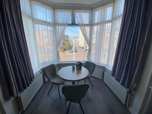 斯海弗宁恩索纳壶伊酒店的配有大窗户的客房内的桌椅