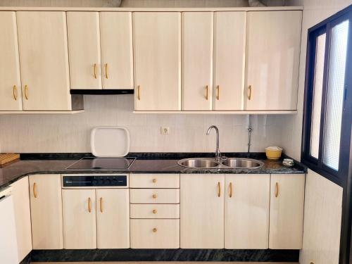阿尔苏阿A CONDA的厨房配有白色橱柜和水槽