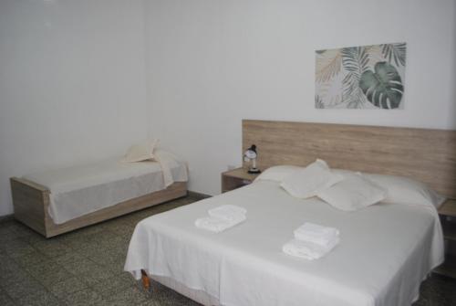 卡塔马卡Multiespacio Center的配有白色床单的酒店客房内的两张床